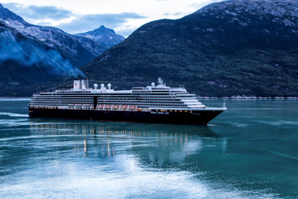 A cruise ship sailing through a lake between mountains