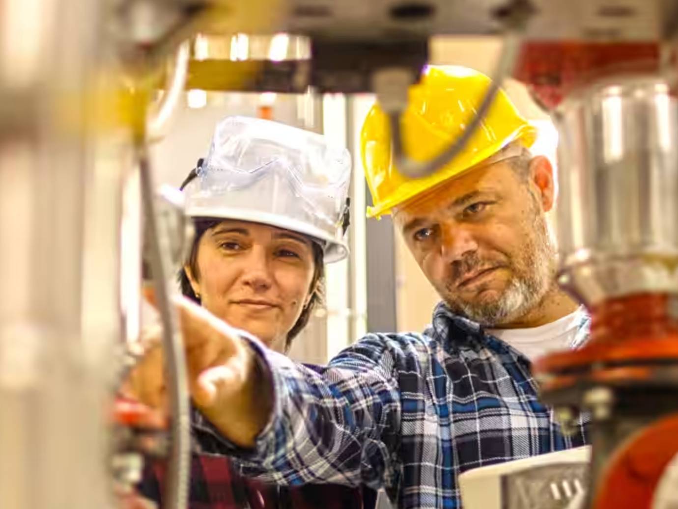 Two mechanics examining something as one of them points