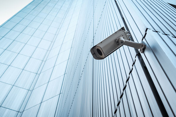 A CCTV camera on the exterior of a tall skyscraper